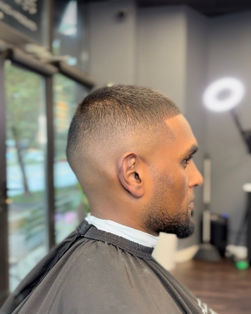Short buzz cut with a high skin fade and sharp line-up, side profile